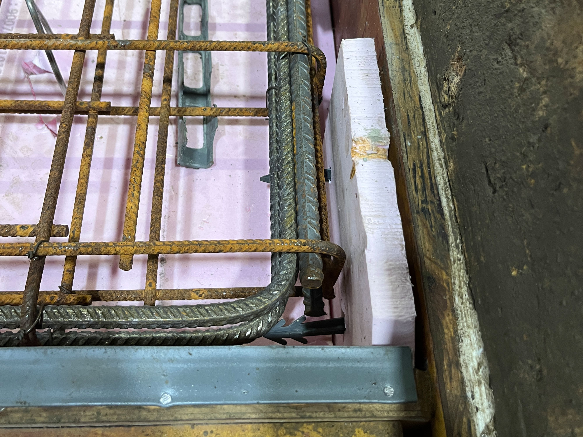 The photo shows a mold for concrete formwork with inserted reinforcing steel and recess formers made from polystyrene.	